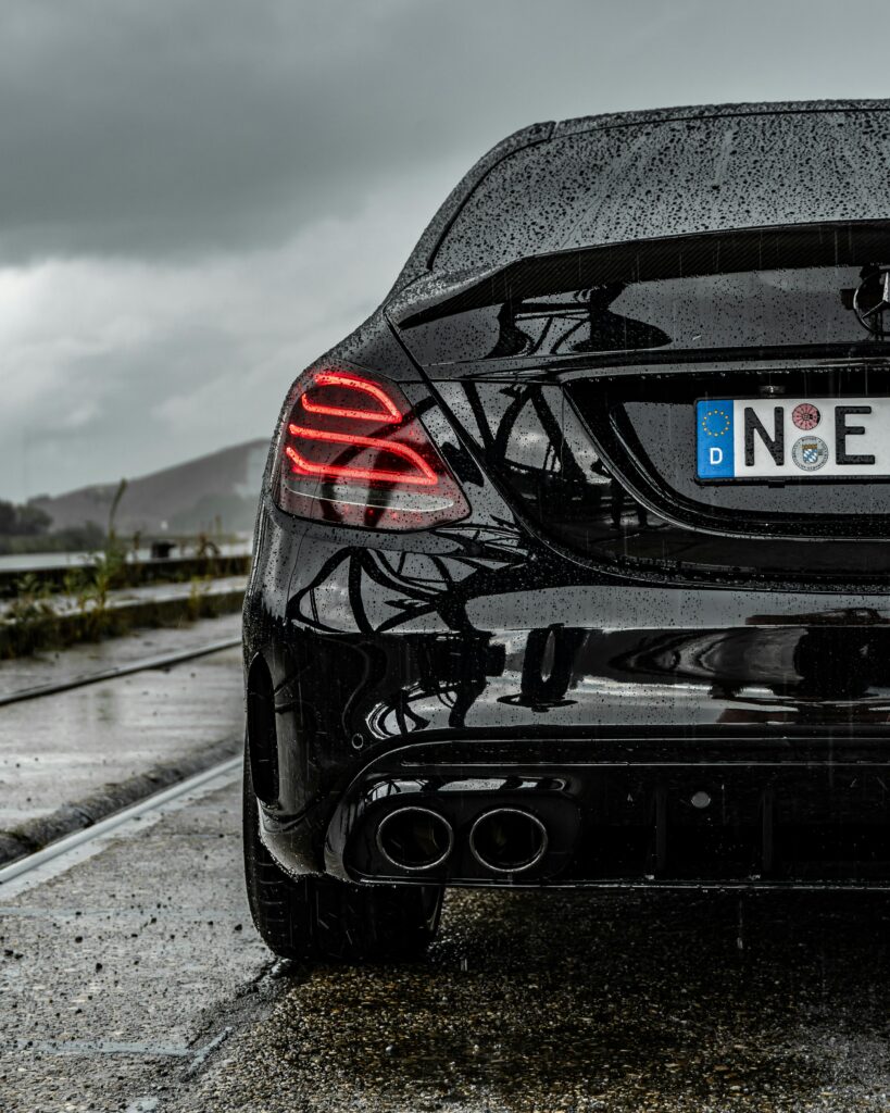Rear view of a black Mercedes coupe on a wet Nürnberg street after rain.