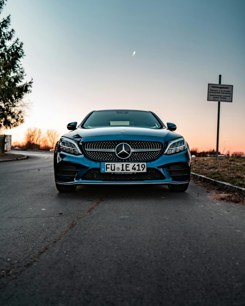 Front view of a luxury Mercedes-Benz parked on a road at sunrise, showcasing elegance and design.