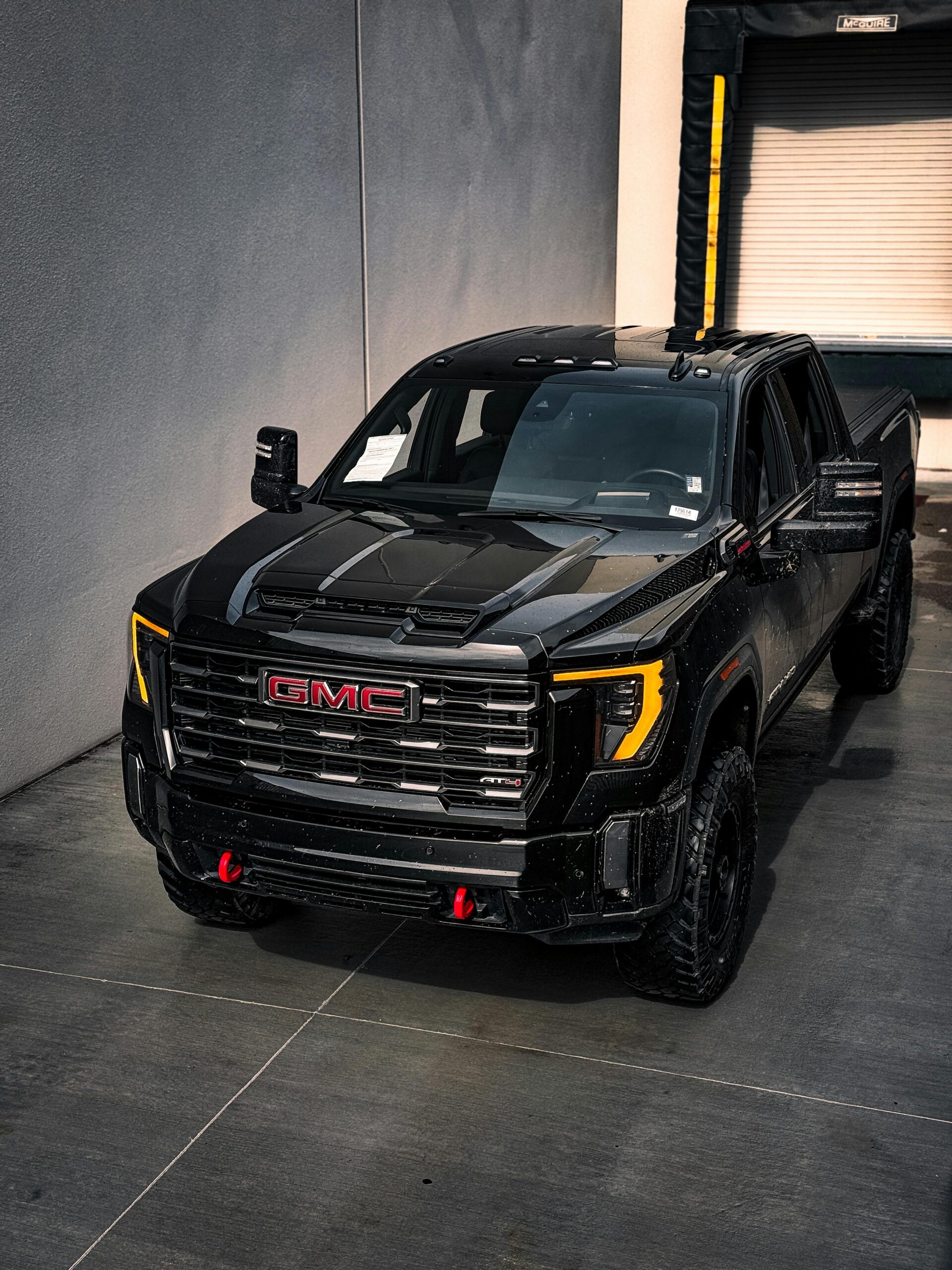 A stylish black GMC truck parked in an urban garage, showcasing modern design.