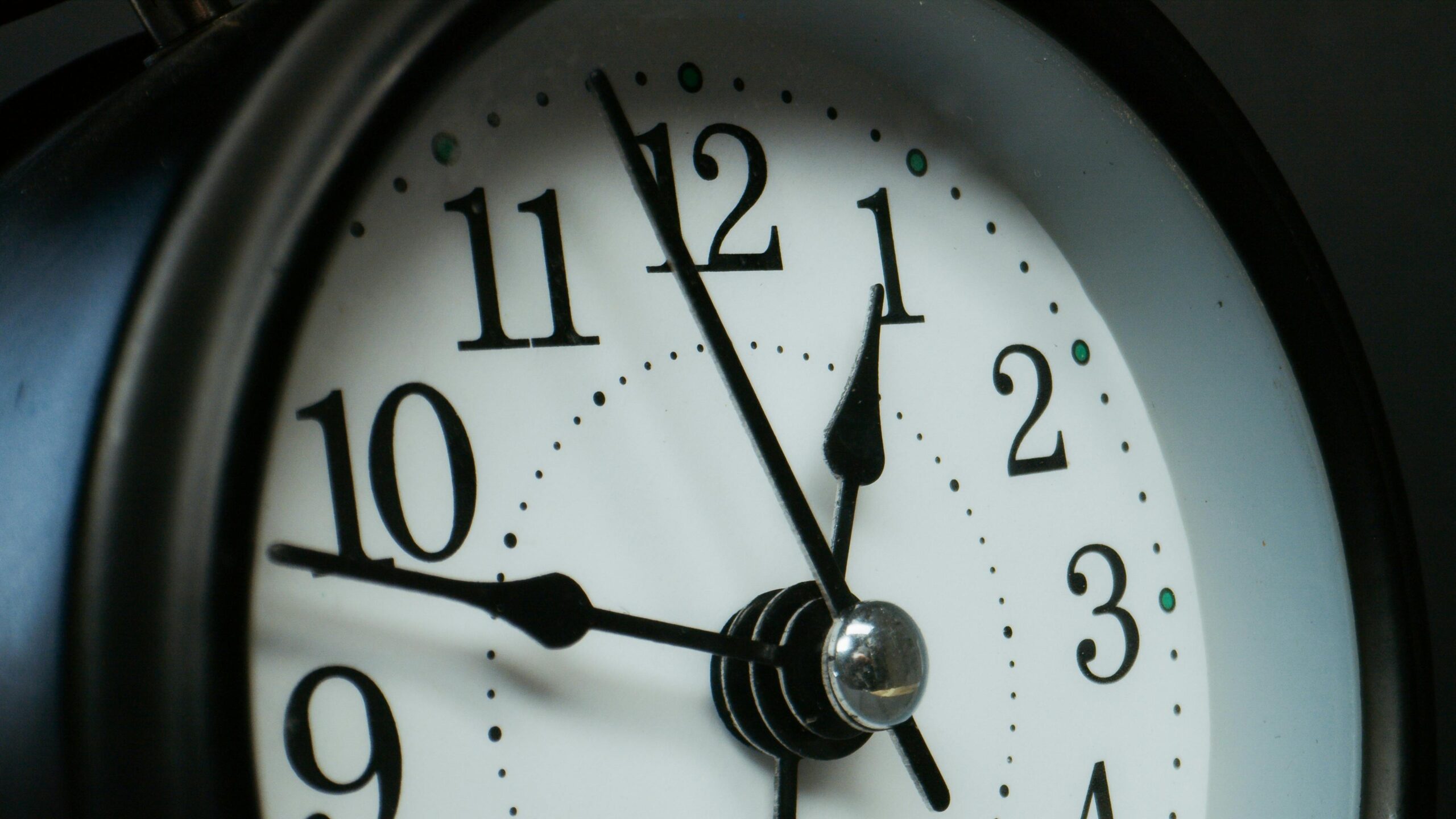 Detailed macro shot of an analog clock showing time at 12:05.